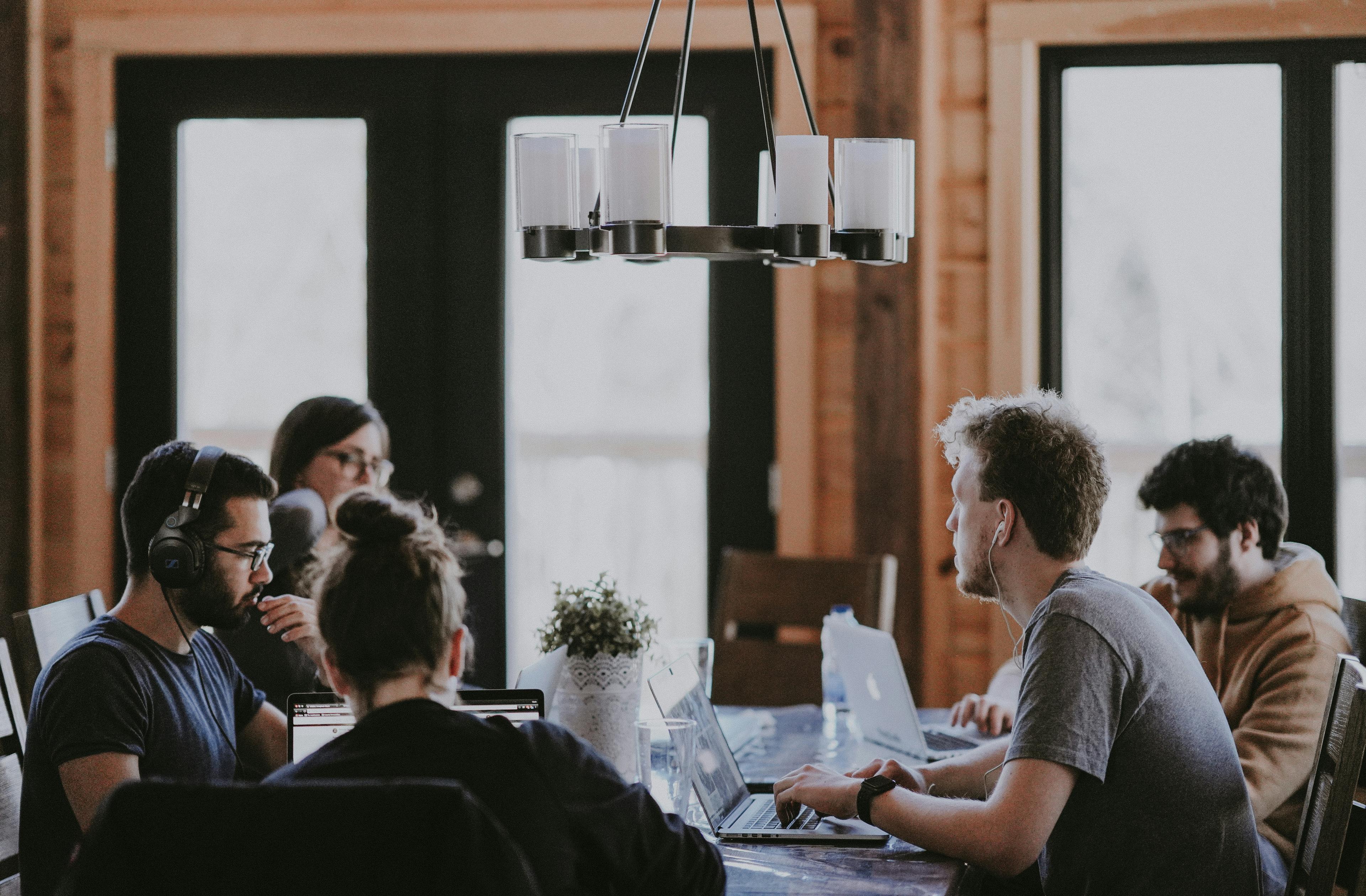 Personas trabajando juntas en una mesa grande en un coworking iluminado